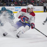 Montreal Canadiens center Rem Pitlick, center, moves the puck while defended by San Jose Sharks defenseman Matt Benning, left, during the second period of an NHL hockey game in San Jose, Calif., Tuesday, Feb. 28, 2023. (AP Photo/Godofredo A. Vásquez)