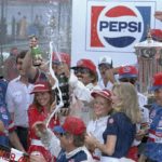 
              FILE - Stock car driver and the winner of the 1984 Daytona Firecracker 400 auto race, Richard Petty of Randleman, N.C., sprays champaign in Victory Lane after he won the race Wednesday, July 4, 1984, at Daytona International Speedway in Daytona Beach, Fla. (AP Photo/Elliot Schecter, File)
            