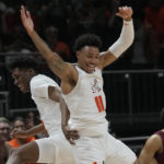 Miami guard Jordan Miller (11) and forward Anthony Walker (1) celebrate after Walker dunked the ball during the first half of an NCAA college basketball game against Florida State, Saturday, Feb. 25, 2023, in Coral Gables, Fla. (AP Photo/Marta Lavandier)