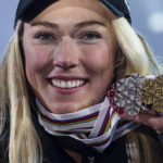 
              United States' Mikaela Shiffrin shows her silver medal of the women's World Championship slalom, the gold medal of the giant slalom and the silver of the combined, in Meribel, France, Saturday Feb. 18, 2023. (AP Photo/Alessandro Trovati)
            