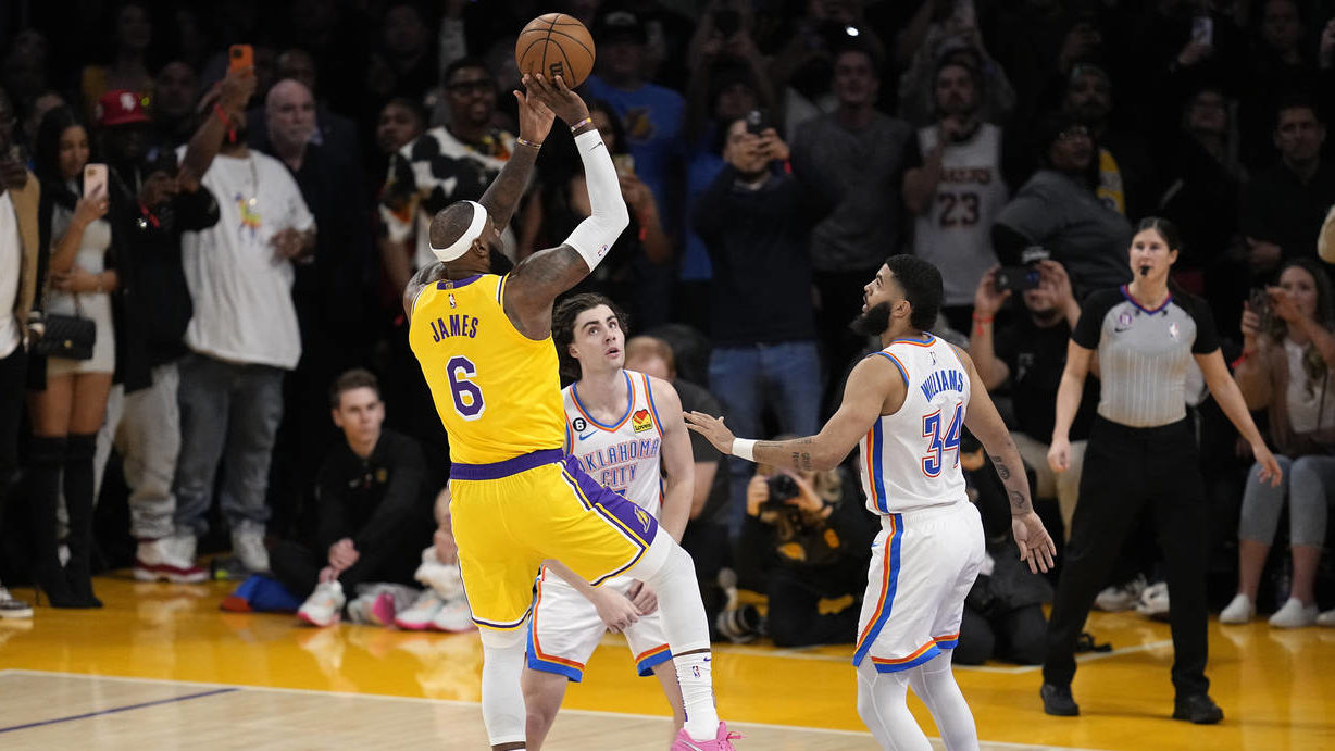 Los Angeles Lakers forward LeBron James, left, scores to pass Kareem Abdul-Jabbar to become the NBA...
