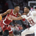 Alabama forward Brandon Miller, left, dribbles the ball against South Carolina forward Gregory Jackson II (23) during the first half of an NCAA college basketball game Wednesday, Feb. 22, 2022, in Columbia, S.C. (AP Photo/Sean Rayford)