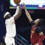 Denver Nuggets guard Reggie Jackson, left, shoots against Cleveland Cavaliers guard Darius Garland (10) during the first half of an NBA basketball game, Thursday, Feb. 23, 2023, in Cleveland. (AP Photo/Ron Schwane)