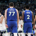 Dallas Mavericks' Luka Doncic (77) and Kyrie Irving (2) talk at mid court during the first half of an NBA basketball game against the Minnesota Timberwolves, Monday, Feb. 13, 2023, in Dallas. (AP Photo/Tony Gutierrez)