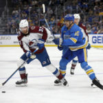Colorado Avalanche's J.T. Compher (37) looks to pass the puck while under pressure from St. Louis Blues' Brayden Schenn (10) during the third period of an NHL hockey game Saturday, Feb. 18, 2023, in St. Louis. (AP Photo/Scott Kane)