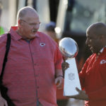 Kansas City Chiefs head coach Andy Reid, left, hands off the Vince Lombardi Trophy to Kansas City Mayor Quinton Lucas, right, after the team returned home a day after winning the NFL Super Bowl 57 football game, Monday, Feb. 13, 2023, in Kansas City, Mo. (AP Photo/Colin E. Braley)