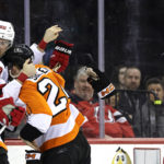 New Jersey Devils center Michael McLeod (20) fights with Philadelphia Flyers defenseman Nick Seeler during the second period of an NHL hockey game Saturday, Feb. 25, 2023, in Newark, N.J. (AP Photo/Adam Hunger)