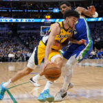 Indiana Pacers guard Chris Duarte controls the ball as Dallas Mavericks guard Kyrie Irving defends during the first half of NBA basketball game in Dallas, Tuesday, Feb. 28, 2023. (AP Photo/Sam Hodde)