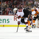
              New Jersey Devils center Jack Hughes (86) is knocked off his skates by Philadelphia Flyers defenseman Justin Braun during the first period of an NHL hockey game Saturday, Feb. 25, 2023, in Newark, N.J. (AP Photo/Adam Hunger)
            