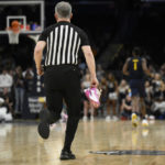 
              An official carries the shoe belonging to Georgetown forward Bradley Ezewiro up court during the second half of an NCAA college basketball game between Georgetown and Marquette, Saturday, Feb. 11, 2023, in Washington. Marquette won 89-75. (AP Photo/Nick Wass)
            