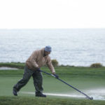 
              A groundkeeper pushes water out of the 5th green of the Pebble Beach Golf Links during the third round of the AT&T Pebble Beach Pro-Am golf tournament in Pebble Beach, Calif., Sunday, Feb. 5, 2023. (AP Photo/Godofredo A. Vásquez)
            