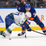Vancouver Canucks' Tyler Myers (57) fights for control of the puck with New York Islanders' Zach Parise (11) during the second period of an NHL hockey game Thursday, Feb. 9, 2023, in Elmont, N.Y. (AP Photo/Frank Franklin II)