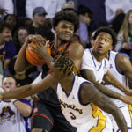 
              Houston's Jarace Walker tries to keep the ball from East Carolina's RJ Felton (3) and Brandon Johnson, right, during an NCAA college basketball game in Greenville, N.C., Saturday, Feb. 25, 2023. (AP Photo/Ben McKeown)
            