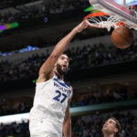 Minnesota Timberwolves center Rudy Gobert (27) dunks over Dallas Mavericks' Dwight Powell, right, as Luka Doncic, left, looks on in the first half of an NBA basketball game, Monday, Feb. 13, 2023, in Dallas. (AP Photo/Tony Gutierrez)
