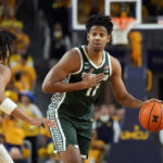 Michigan State guard A.J. Hoggard (11) brings the ball up court during the first half of an NCAA college basketball game against Michigan, Saturday, Feb. 18, 2023, in Ann Arbor, Mich. (AP Photo/Carlos Osorio)