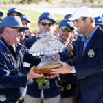 
              Scottie Scheffler, right, is presented the championship trophy by tournament chairman Pat Williams after the final round of the Phoenix Open golf tournament, Sunday, Feb. 12, 2023, in Scottsdale, Ariz. (AP Photo/Darryl Webb)
            