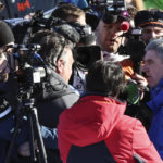 IOC (International Olympic Committee) President Thomas Bach, right, meets the media in the finish area of the alpine ski, men's World Championship downhill, in Courchevel, France, Sunday, Feb. 12, 2023. (AP Photo/Marco Trovati)