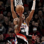 
              Portland Trail Blazers guard Damian Lillard, front, shoots over Oklahoma City Thunder guard Aaron Wiggins during the first half of an NBA basketball game in Portland, Ore., Friday, Feb. 10, 2023. (AP Photo/Steve Dykes)
            
