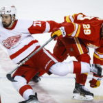 
              Detroit Red Wings forward Dylan Larkin, left, is checked by Calgary Flames forward Dillon Dube during second-period NHL hockey game action in Calgary, Alberta, Thursday, Feb. 16, 2023. (Jeff McIntosh/The Canadian Press via AP)
            