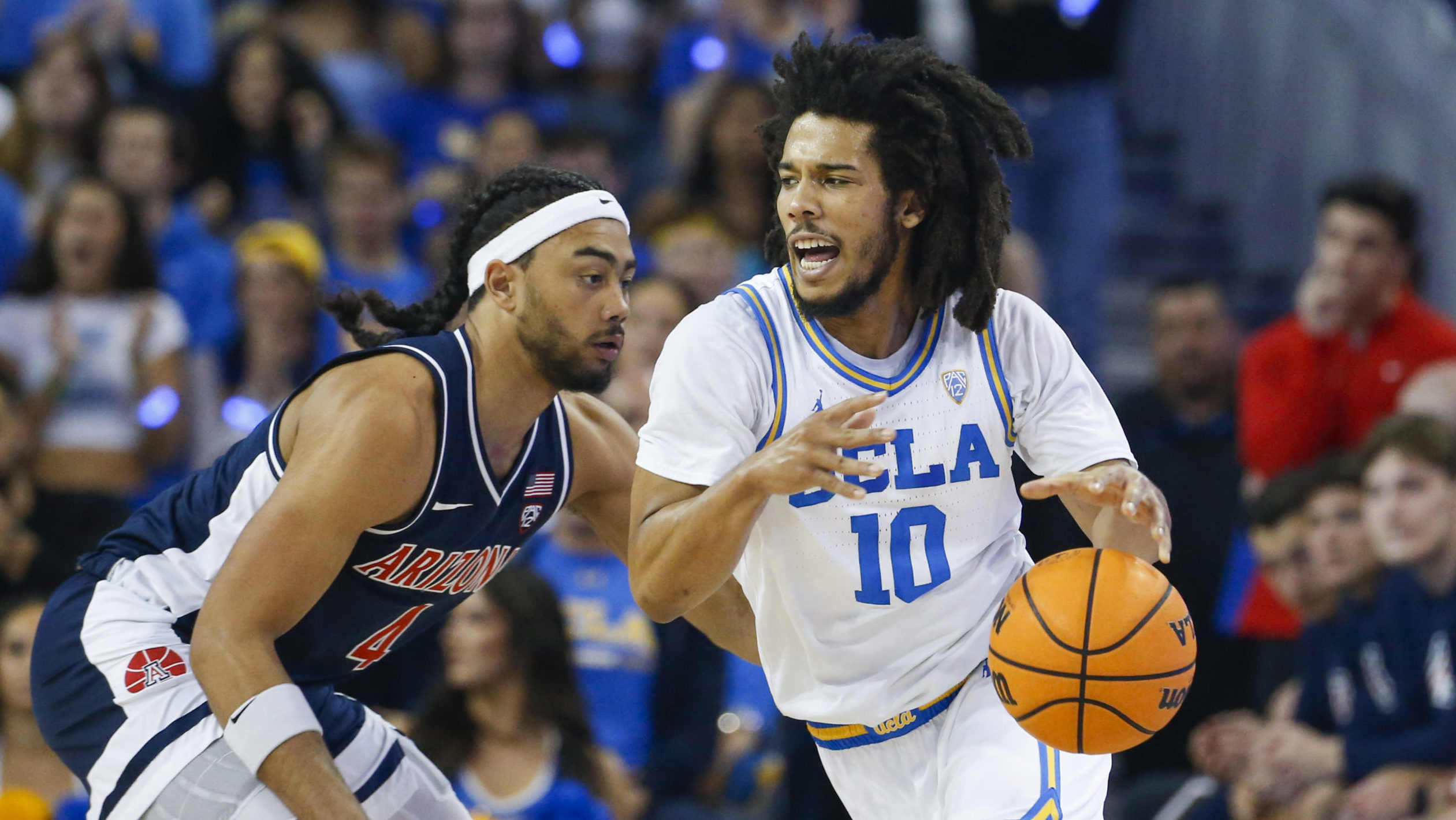 UCLA guard Tyger Campbell, right, drives past Arizona guard Kylan Boswell during the first half of ...