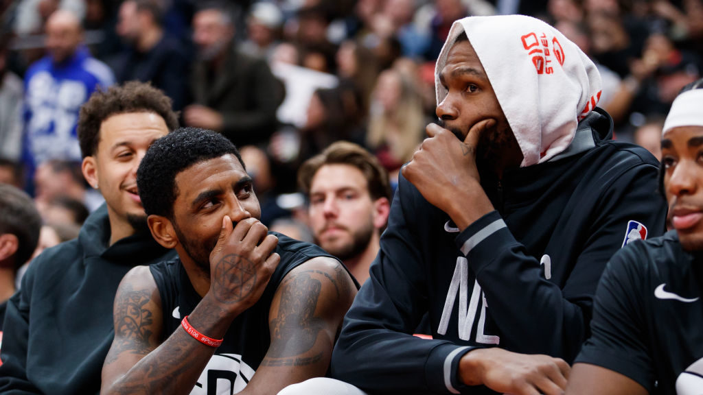 Kyrie Irving #11 and Kevin Durant #7 of the Brooklyn Nets walk on the bench during the second half ...