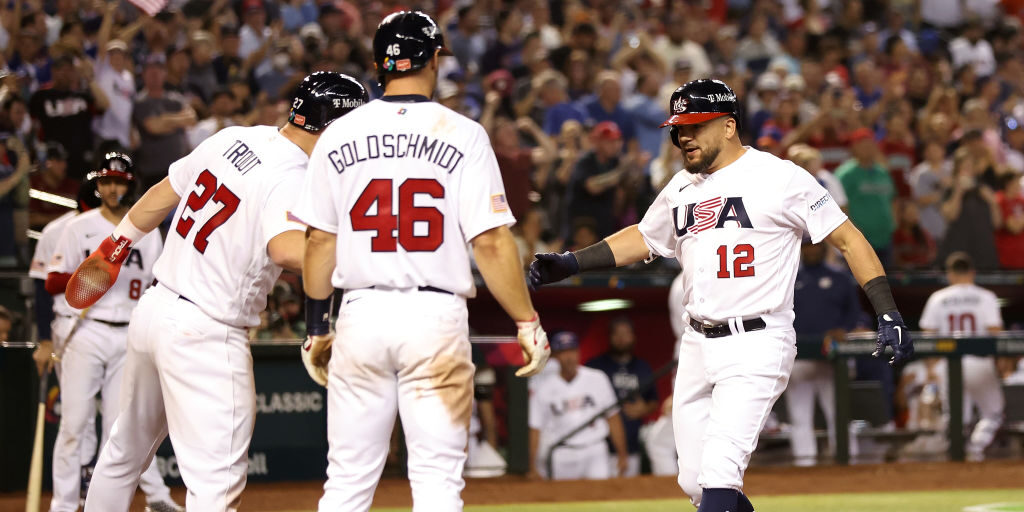Kyle Schwarber #12 of Team USA is congratulated by Mike Trout #27 and Paul Goldschmidt #46 after hi...