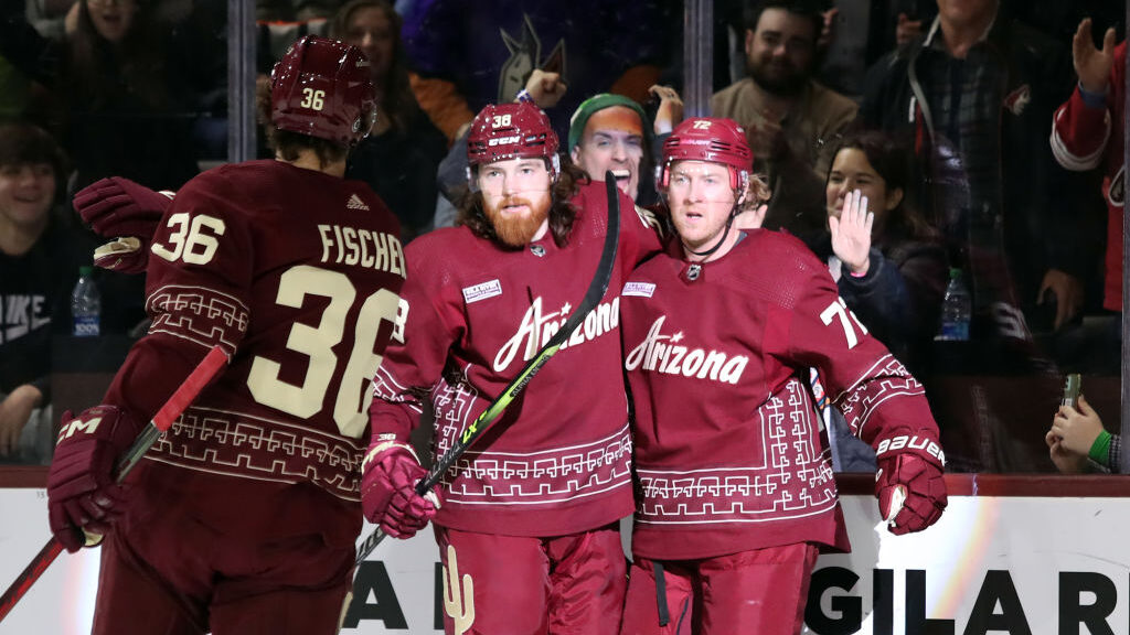 Travis Boyd #72 of the Arizona Coyotes celebrates with Liam O'Brien #38 and Christian Fischer #36 a...