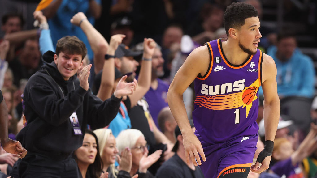 Devin Booker #1 of the Phoenix Suns reacts after a three-point shot against the Philadelphia 76ers ...