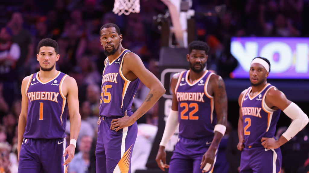 Devin Booker #1, Kevin Durant #35, Deandre Ayton #22 and Josh Okogie #2 of the Phoenix Suns stand o...