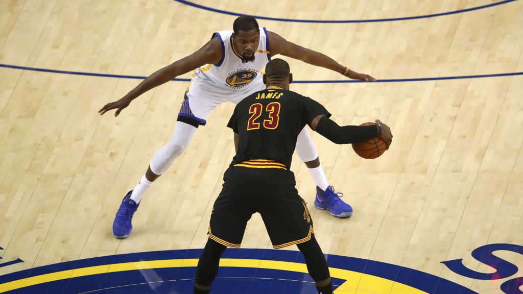 LeBron James #23 of the Cleveland Cavaliers is defended by Kevin Durant #35 of the Golden State War...