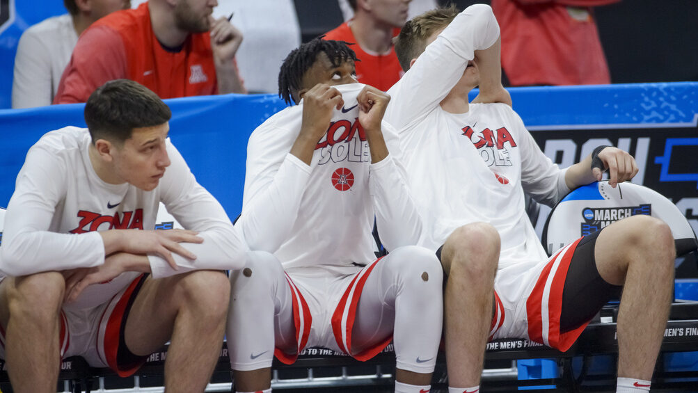 Arizona players sit on the bench in the final seconds of a first-round college basketball game agai...