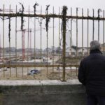 
              A man watches the construction site of the Olympic Village at the Porta Romana former railway yard, in Milan, Italy, Wednesday, March 1, 2023. There is little sign the Winter Olympics are coming to Milan in less than three years. One of the major sites is still an overgrown wasteland and there is minimal construction work at what will be the Olympic Village. The organizing committee for the 2026 Milan-Cortina Olympics says there have been delays and rising costs. (AP Photo/Luca Bruno)
            