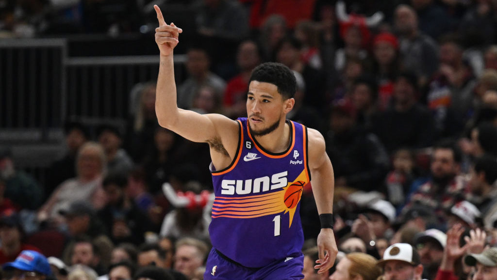 Devin Booker #1 of the Phoenix Suns reacts after making a three-point basket in the first half agai...