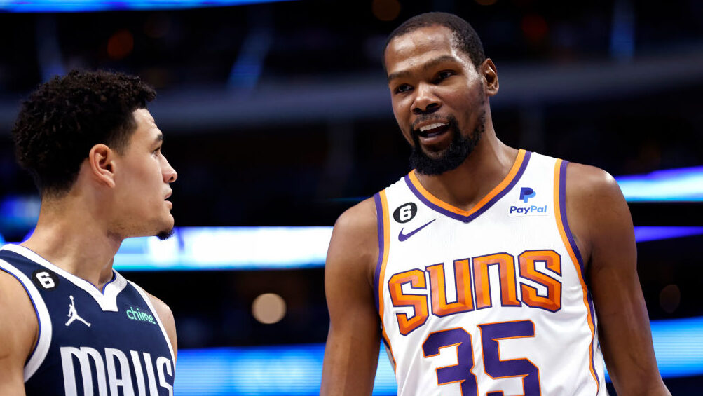 Kevin Durant #35 of the Phoenix Suns and Josh Green #8 of the Dallas Mavericks talk during a break ...