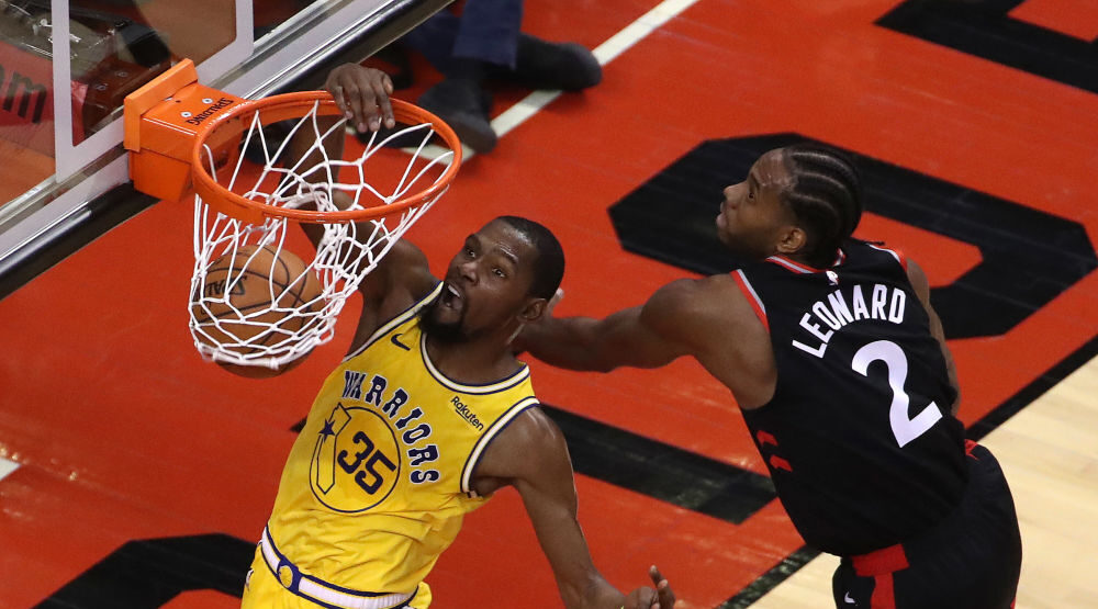 Golden State Warriors forward Kevin Durant (35) dunks after passing Toronto Raptors forward Kawhi L...