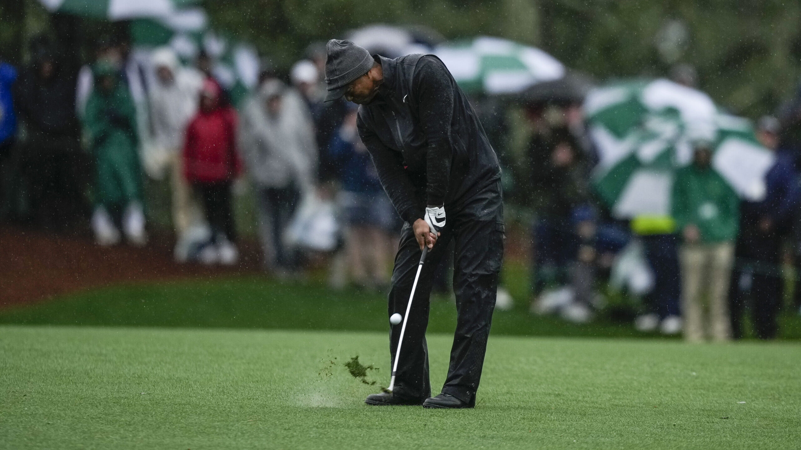 Tiger Woods hits from the fairway on the 15th hole during the weather delayed third round of the Ma...