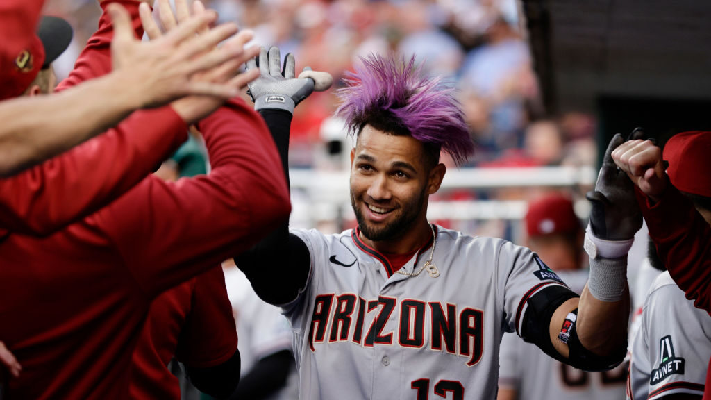 Lourdes Gurriel Jr. #12 of the Arizona Diamondbacks is congratulated in the dugout after hitting a ...