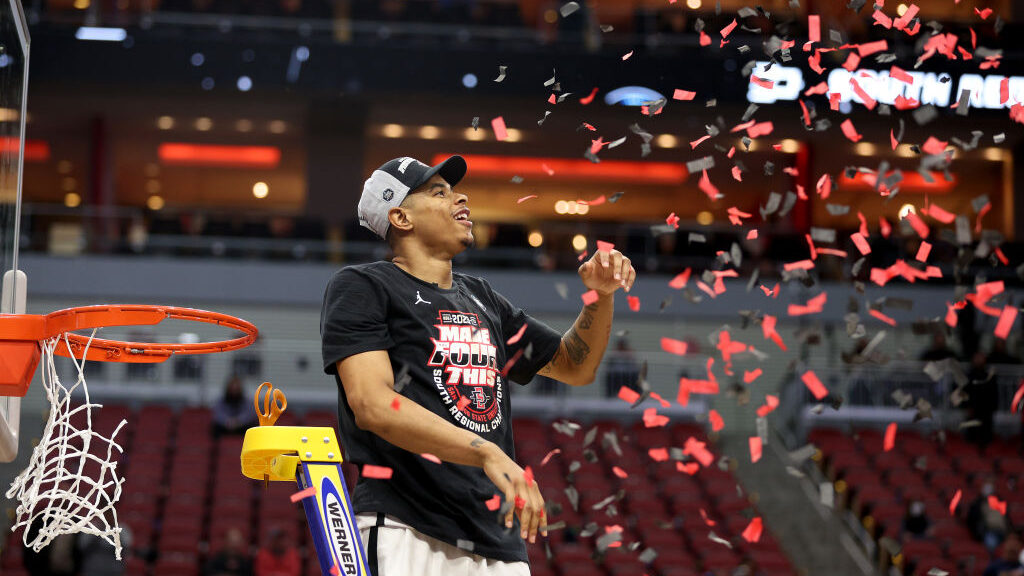 Keshad Johnson #0 of the San Diego State Aztecs celebrates by cutting down the net after defeating ...