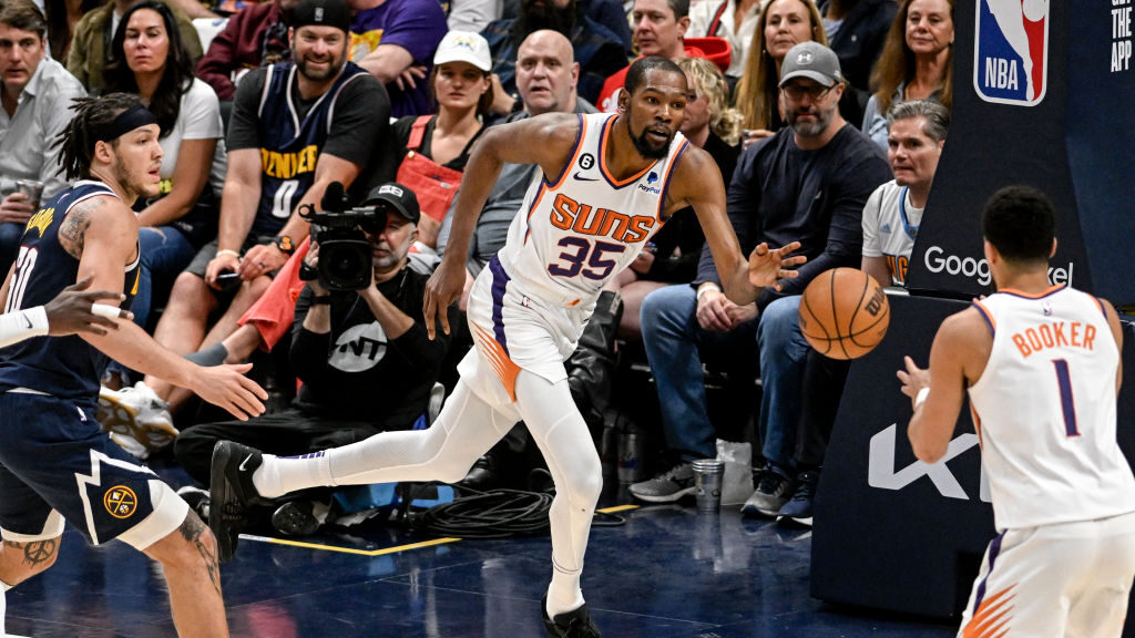 Kevin Durant (35) of the Phoenix Suns saves the ball and passes to Devin Booker (1) against the Den...