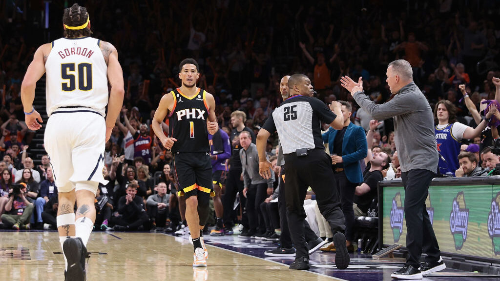 Devin Booker #1 of the Phoenix Suns reacts after a three-point shot against the Denver Nuggets duri...