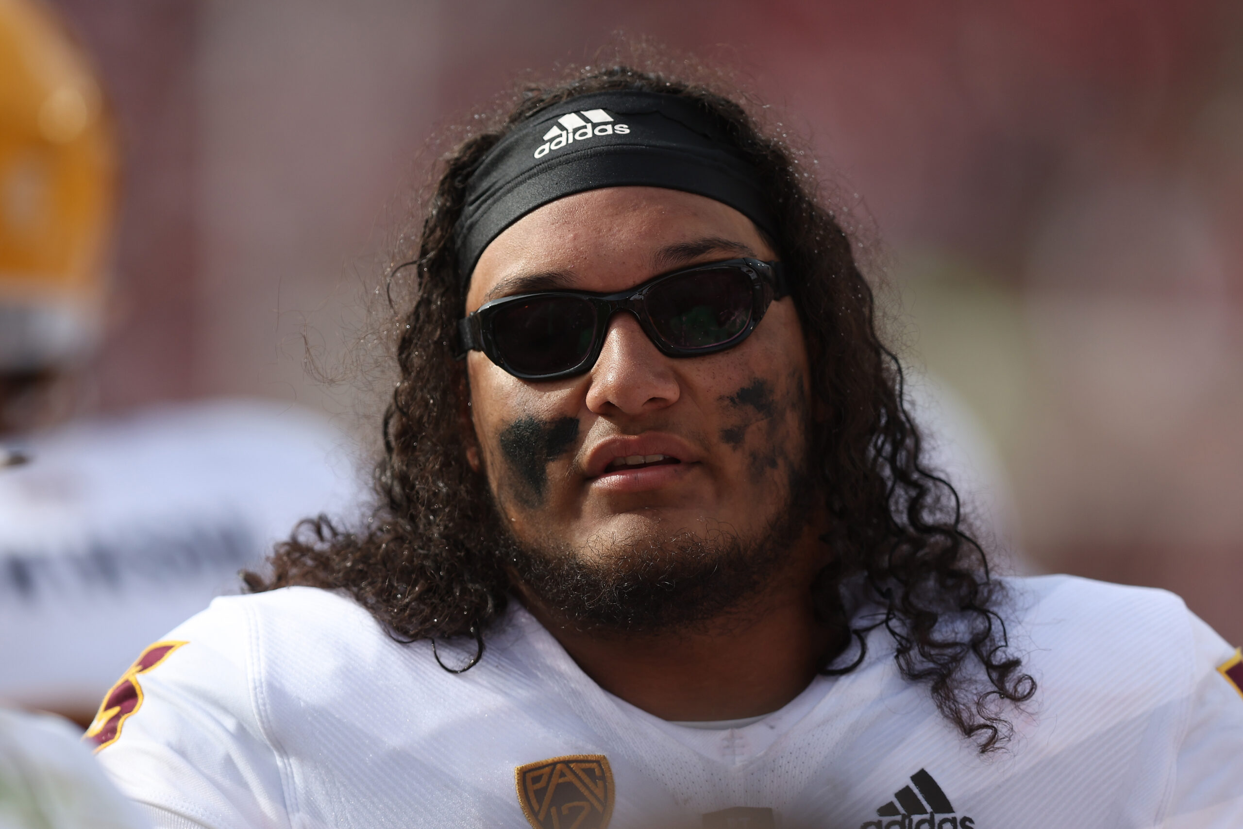 Offensive lineman Isaia Glass #73 of the Arizona State Sun Devils looks on from the sideline in the...
