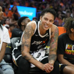 Phoenix Mercury center Brittney Griner smiles at the fans as she sits between Mercury's Shey Peddy, left, and Evina Westbrook, right, during the first half of a WNBA basketball game against the Chicago Sky, Sunday, May 21, 2023, in Phoenix. (AP Photo/Ross D. Franklin)Credit: ASSOCIATED PRESS