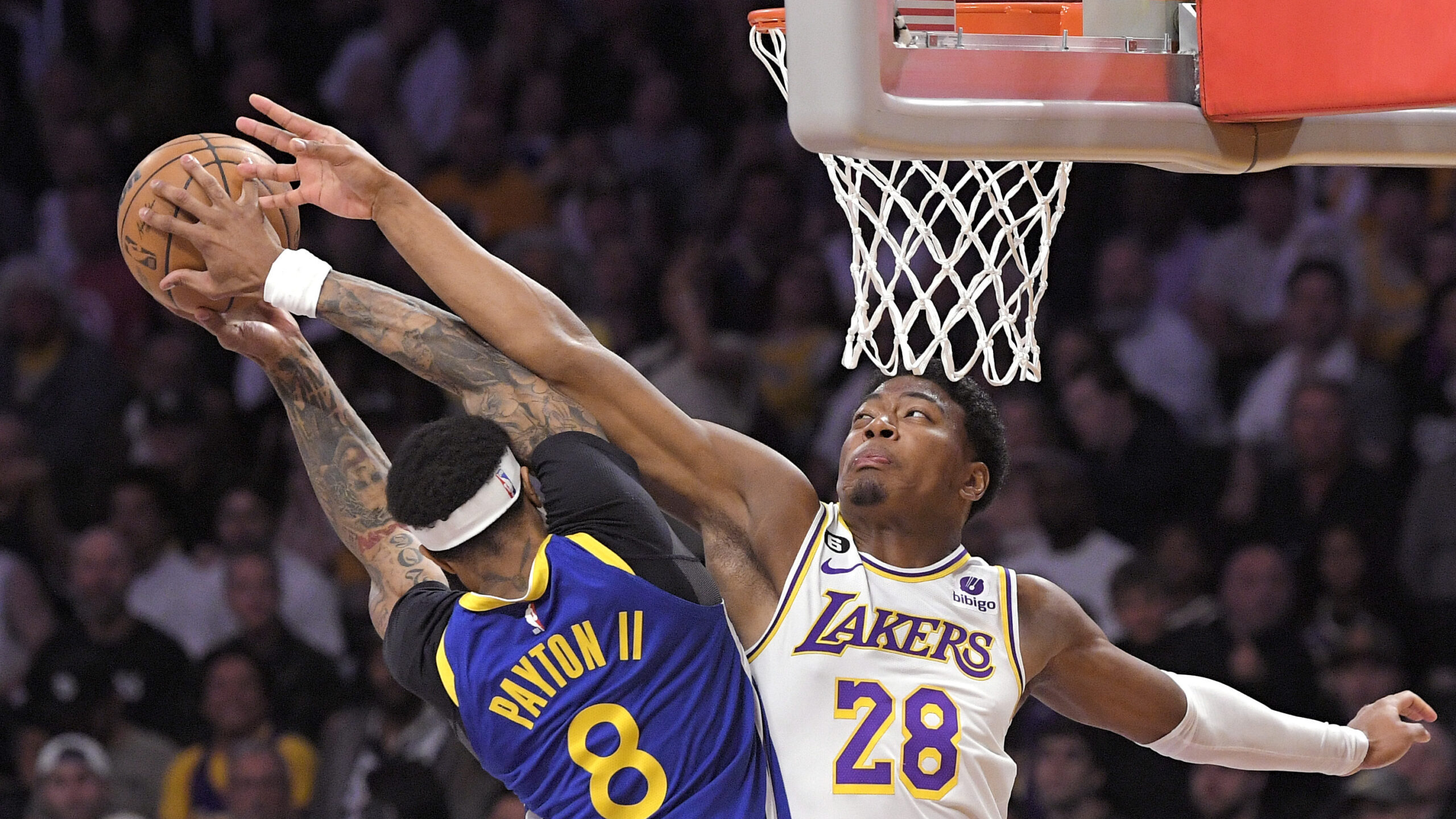 Golden State Warriors guard Gary Payton II, left, shoots as Los Angeles Lakers forward Rui Hachimur...