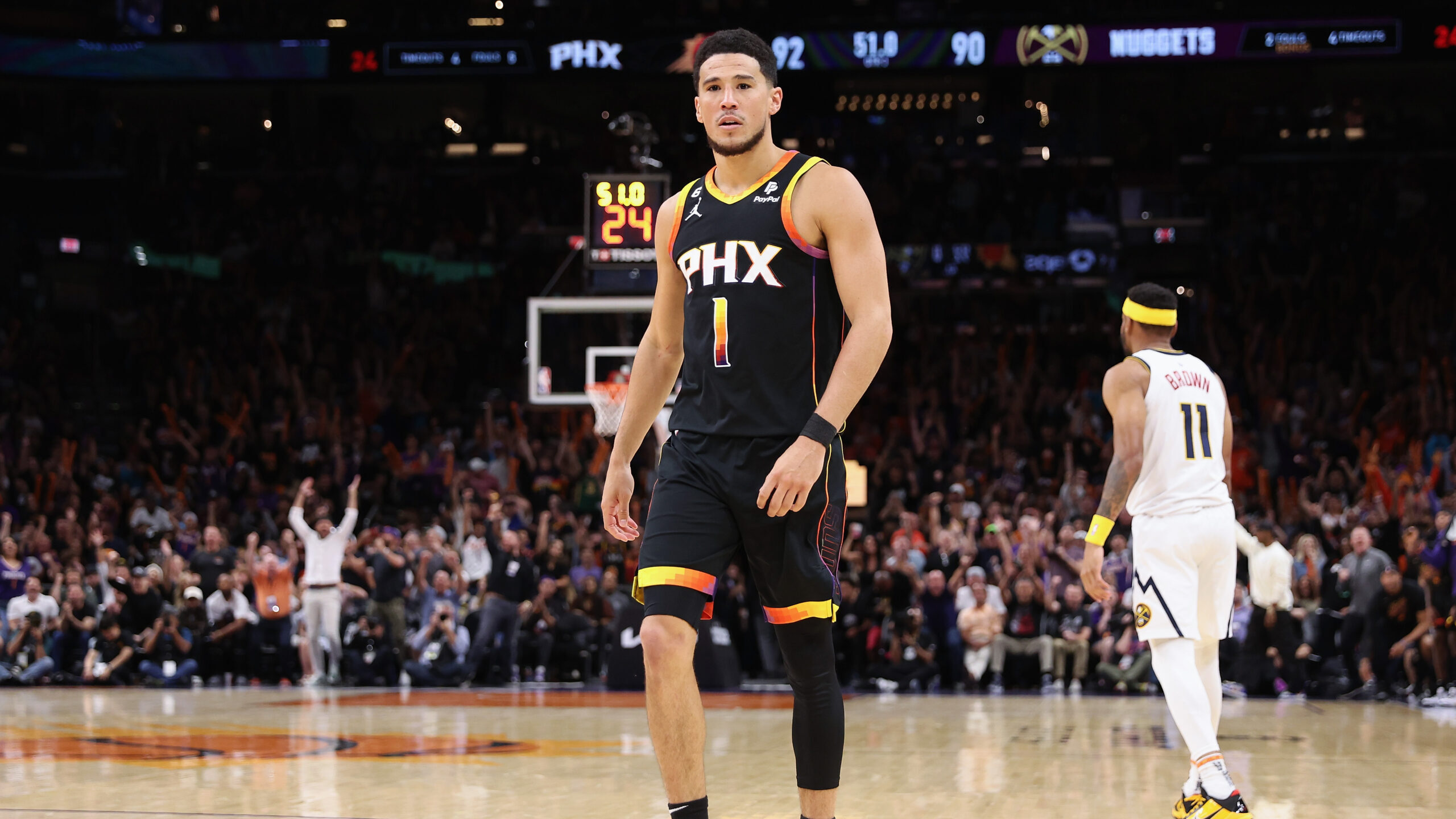 Devin Booker #1 of the Phoenix Suns reacts after scoring against the Denver Nuggets during the seco...