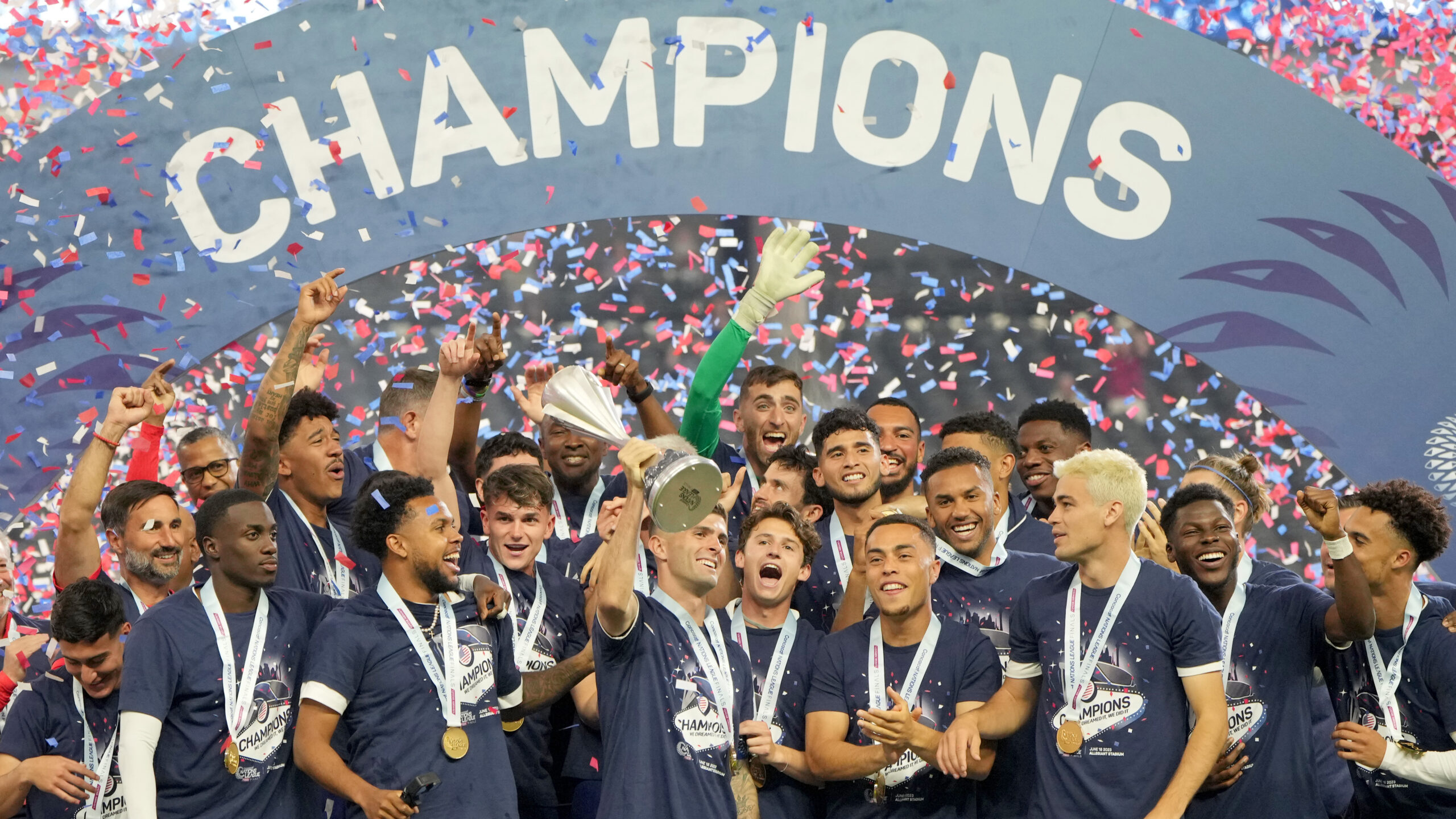 Christian Pulisic #10 of the United States lifts the trophy as United States players celebrate winn...