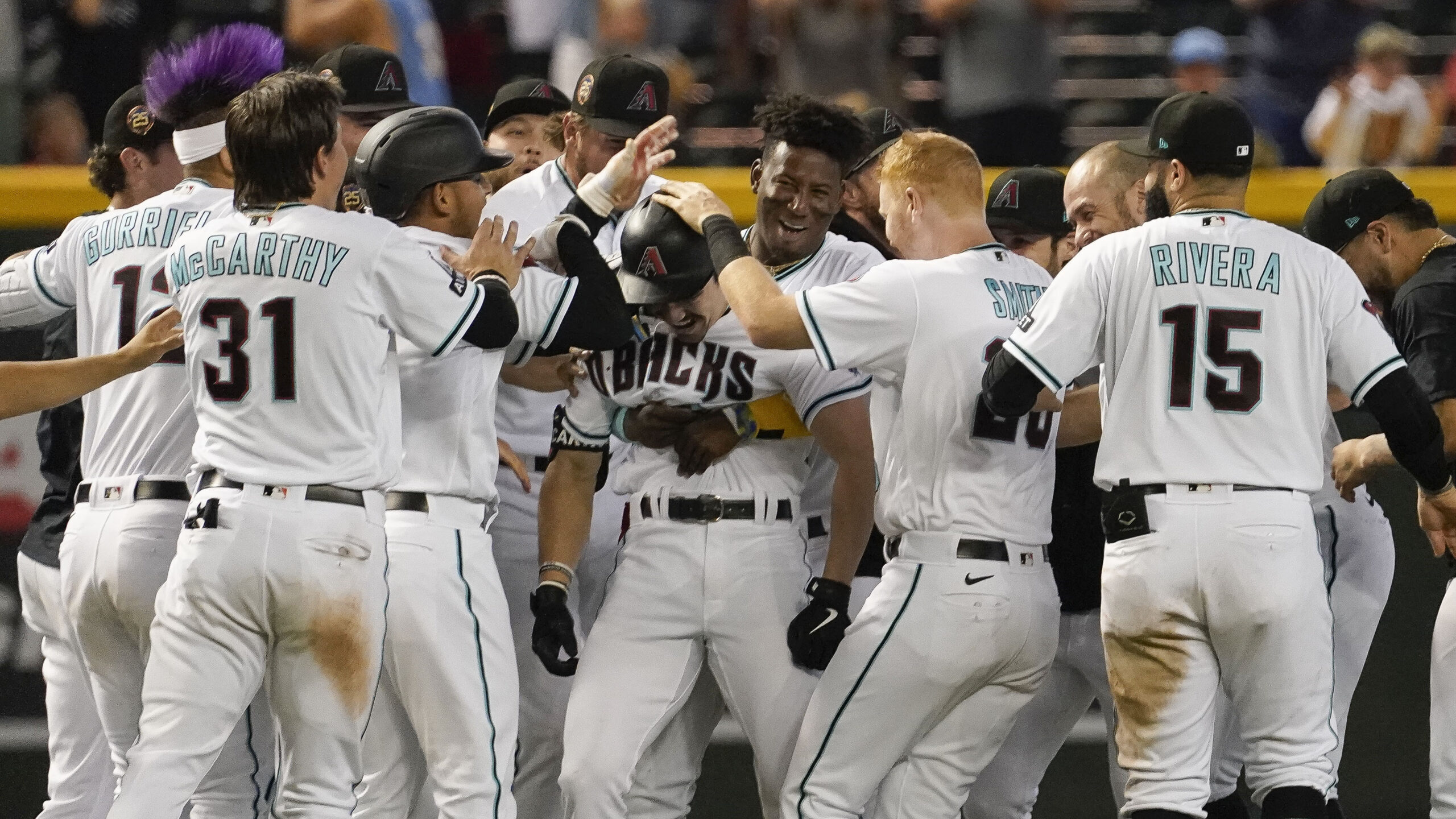 Arizona Diamondbacks mob Corbin Carroll, middle, after he drove in two runs with a single against t...