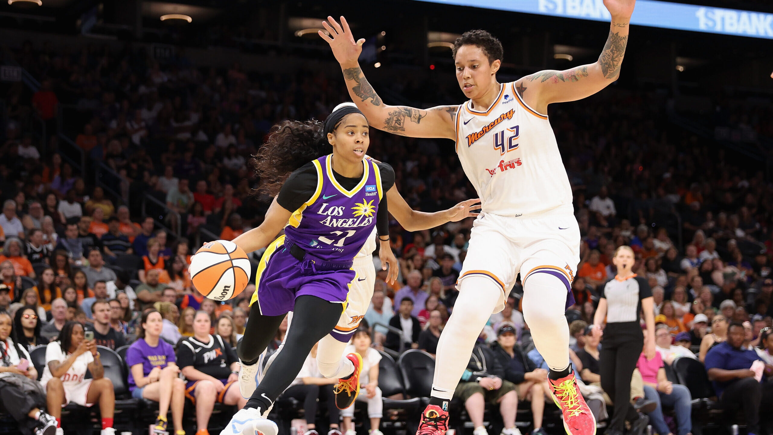 Jordin Canada #21 of the Los Angeles Sparks drives the ball past Brittney Griner #42 of the Phoenix...