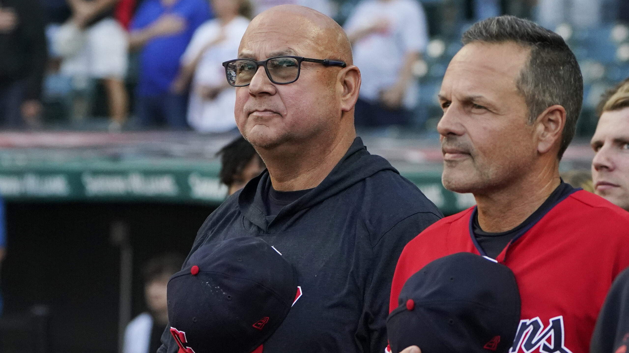 Cleveland Guardians manager Terry Francona, left, stands for the national anthem next to third base...