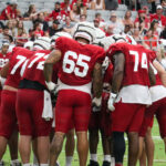 The Arizona Cardinals offense huddles during the Red & White practice on Saturday, Aug. 5, 2023, in Glendale. (Tyler Drake/Arizona Sports)