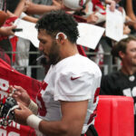 Arizona Cardinals OLB Zaven Collins signs an autograph during Red & White practice on Saturday, Aug. 5, 2023, in Glendale. (Tyler Drake/Arizona Sports)